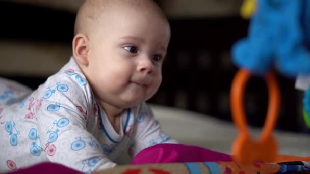 新生児アクティブ赤ちゃんかわいい笑顔歯のない顔の肖像胃の開発ネックコントロールの初期の頃.プレイペンで5ヶ月の子供Gnowsおもちゃカメラを見てください。幼児、出産、概念の開始 — ストック動画