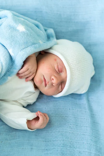 Novorozené Dítě Červené Roztomilé Tvář Portrét Počátky Spánek V Lékařské Skleněné Postele Na Modrém Pozadí. Dítě na začátku minuty života na klobouku. Kojenci, porod, první okamžiky narození, počátky konceptu — Stock fotografie