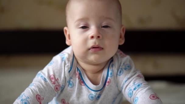新生児アクティブ赤ちゃんかわいい笑顔歯のない顔の肖像胃の開発ネックコントロールの初期の頃.5カメラを見て白いベッドの上のヶ月の子供.幼児、出産、親、概念の開始 — ストック動画