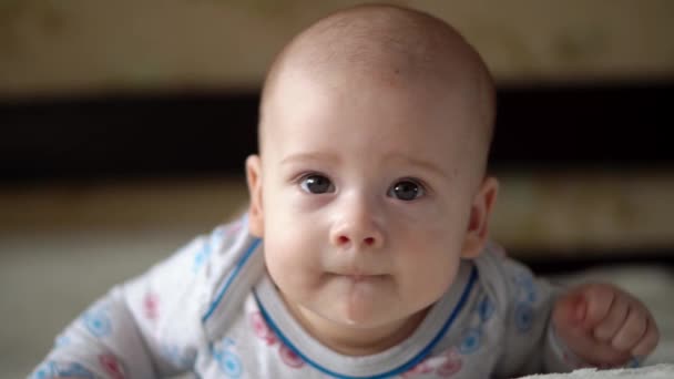 Новорожденный Активный Baby Cute Smiling Беззубый Портрет Фейса Ранние дни на контроле развития шеи желудка. 5 месяцев ребенка на белой кровати, глядя на камеру. Младенец, Рождение ребенка, Родительство, Начало концепции — стоковое видео