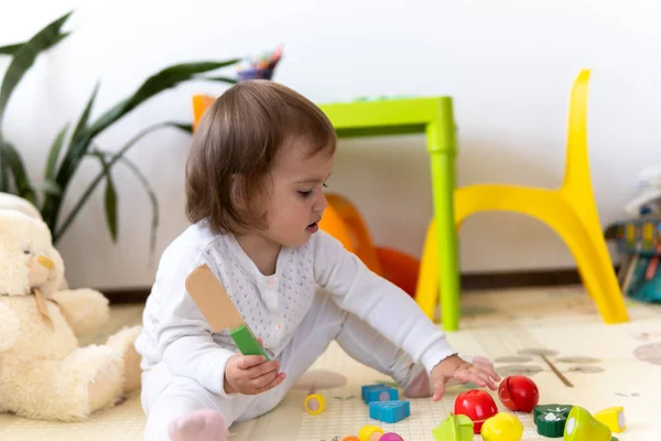 教育用のおもちゃのブロックの花を持つ幸せな面白い子供の巻き赤ちゃんの女の子。保育園や保育園で遊ぶ子どもたち。子供部屋でメス。幼稚園で幼児のビルドタワー。カラフルなおもちゃで遊ぶ子供 — ストック写真