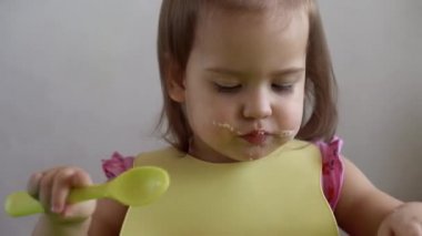Güzel bir kızın kahvaltıda yumurta yemesine yakın evde tek başına sebze sosisi yiyor. Sevimli, mutlu, yeni yürümeye başlayan çocuk evde kirli suratıyla yemek yiyor. Yiyecek, beslenme sağlıklı yaşam