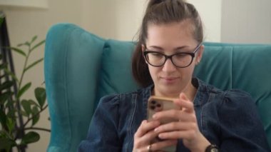 Yüzü Otantik Genç Kadın Salonda Telefonda Sohbet Ediyor. Kullanarak Yazma Araması. Smartphone İnternet 'te Çalışan Mutlu Gülümseyen Kadın. Buisenes, Eğitim, Teknoloji Konsepti