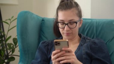 Yüzü Otantik Genç Kadın Salonda Telefonda Sohbet Ediyor. Kullanarak Yazma Araması. Smartphone İnternet 'te Çalışan Mutlu Gülümseyen Kadın. Buisenes, Eğitim, Teknoloji Konsepti