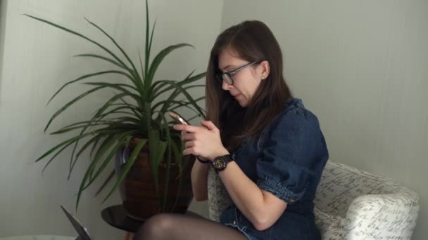 Επιτυχημένη Νεαρή Γυναίκα με γυαλιά Συνομιλία Στο Τηλέφωνο Σαλόνι. Γράφοντας αναζήτηση χρησιμοποιώντας το. Ευτυχισμένο χαμόγελο Buisenes Lady εργάζονται για Smartphone Browsing Internet. Εκπαίδευση, έννοια της τεχνολογίας — Αρχείο Βίντεο
