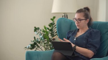 Oturma odasında dizüstü bilgisayarda sohbet eden beyaz bir kadın. Başarılı iş kadını Masa 'daki konferansı yönetiyor. İnternet, Eğitim, Teknoloji Konsepti Üzerinde Çalışan Mutlu Öğretmen