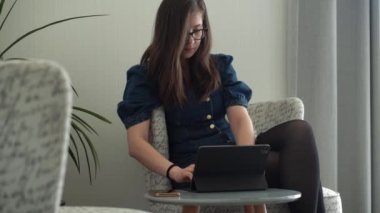 Gözlüklü başarılı bir genç kadın telefonda sohbet ediyor. Kullanarak Yazma Araması. Smartphone Browsing Internet 'te çalışan Mutlu Gülümseyen Bayan Buisenes. Eğitim, Teknoloji Konsepti