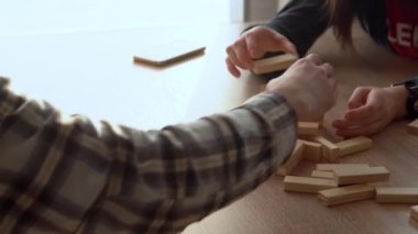 Küçük Çocuklar Masada ailesiyle küçük Jenga oynuyorlar, Jenga Kulesi dağılıyor, Aileler evde harika vakit geçiriyorlar Güneşli odada oyun oynuyorlar, Mutlu çocukluk, Arkadaşlık konsepti