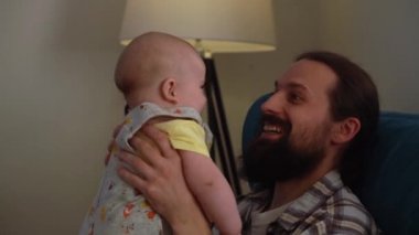 Genç neo babasının sinematik yakın çekimi. Babası akşam üzeri yeni doğan oğluyla kreşte oynuyor. Çocukların ebeveynlik, çocukluk, hayat, aşk, babalık, aile kavramları