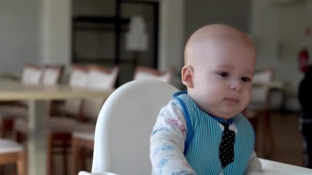 Mamma mamma alimenta il bambino in bianco nutrendosi del seggiolone, primo integratore di purea vegetale Buon bambino sorridente mangia per la prima volta, bambino con la faccia sporca, bambino piccolo che mangia porridge nutrizione — Video Stock