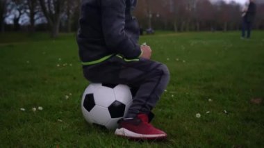 Mutlu çocuk ailesi bahar parkında eğleniyor. Küçük Çocuk Koş. Siyah beyazın üzerinde oturan çocuk klasik futbol topu yeşil çimlerin üzerinde. İnsanlar futbol oynuyor. Çocukluk, Spor, Şampiyonluk Konsepti