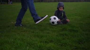 Baba ve Küçük Oğul Hokkabazlık Yarışması Siyah ve Beyaz Klasik Futbol Balosu. İnsanlar spor için içeri giriyor. Genç çocuk futbol oynuyor. Mutlu Aile Ekibi parkta vakit geçirdi. Sağlıklı Yaşam, Şampiyonluk