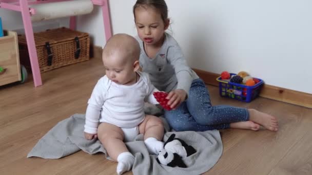 Deux frères et sœurs heureux enfants garçon fille dans la salle de jeu. Enfants Infantile et préscolaire Jouer avec jouet en bois à la maison Construire la construction. Le bébé a passé du temps à la maison. Enfance, Parentalité, Concept d'amitié — Video