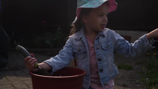 Happy Preschool meisje kind Dochter dragen werkt handschoenen humic laarzen planten bloemen in pot in de tuin. Kind helpt moeder naar buiten. Familie Natuur gardering, milieu Lente Zomer concept — Stockvideo