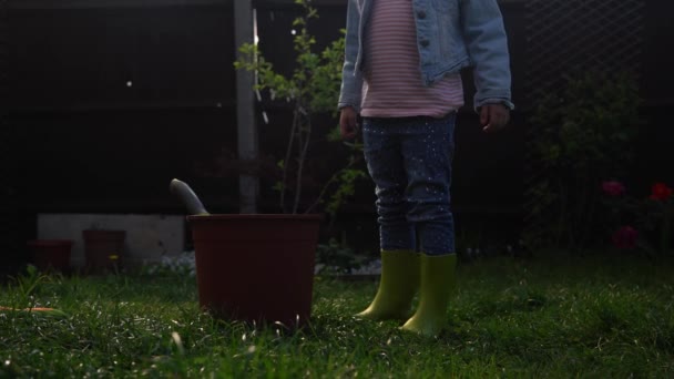 Šťastná školka holčička Dcera nosit pracuje rukavice humic boty sázení květiny v květináči na zahradě. Dítě Pomáhá matce. Rodina Zahradničení přírody, životní prostředí Jaro Letní koncept — Stock video