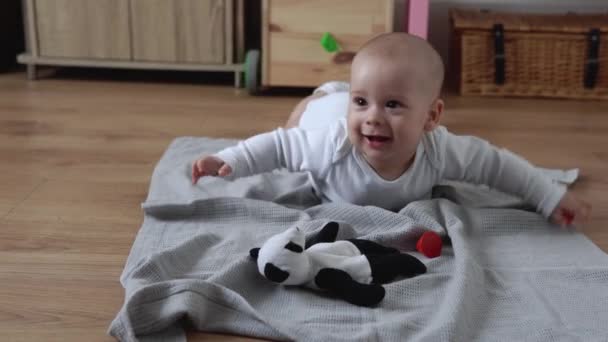 Glückliches Neugeborenes im Spielzimmer. Kleinkinder spielen zu Hause mit Holzspielzeug und bauen Konstruktionen aus geometrischen Figuren. Kinder verbringen Zeit während des Motorikspiels. Kindheit, Elternschaft — Stockvideo