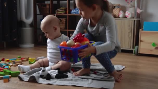 Deux frères et sœurs heureux enfants garçon fille dans la salle de jeu. Enfants Infantile et préscolaire Jouer avec jouet en bois à la maison Construire la construction. Le bébé a passé du temps à la maison. Enfance, Parentalité, Concept d'amitié — Video