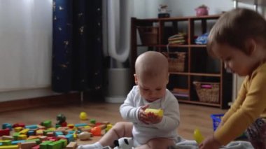 İki Mutlu Kardeşler Oyun Salonundaki Çocuk Kız Çocuğu. Çocuklar Infand ve Anaokulu Ev Yapımı 'nda tahta oyuncaklarla oynuyor. Bebek evde çok zaman geçirdi. Çocukluk, Ebeveynlik, Arkadaşlık Konsepti