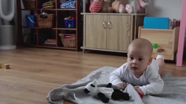 Glad nyfödd baby i lekrummet. Spädbarn barn leka med träleksaker hemma bygga konstruktioner från geometriska figurer. Barn har tillbringat tid under Motor Skills Game. Barndom, föräldrakoncept — Stockvideo