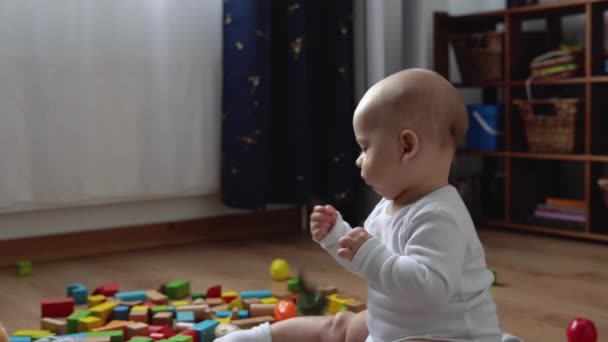 Bebê recém-nascido feliz na sala de jogos. Infant Kid Brincar com brinquedos de madeira em casa Construir construções a partir de figuras geométricas. Criança tem gastar tempo durante o jogo de habilidades motoras. Infância, Conceito de paternidade — Vídeo de Stock