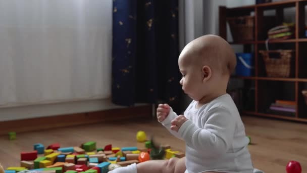 Šťastné novorozeně v herně. Kojenec Kid Hrát S Dřevěné Hračky Doma Stavět Stavby Z Geometrických Figur. Dítě mají trávit čas během hry motorové dovednosti. Dětství, koncepce rodičovství — Stock video