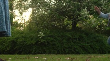 Mutlu bir aile annesi, iki küçük kardeş çocuk sabun köpüğü üflüyor ve yaz tatillerinin tadını çıkarıyorlar. Gülümseyen ebeveynler çocuklar akşam günbatımında birlikte vakit geçiriyorlar.