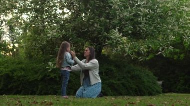 Mutlu aile annesi, koşuşturmaca oynayan üç küçük kardeş anne kucaklaşması yaz tatilinin tadını bahçede ya da parkta çıkarıyor. Gülümseyen ebeveynler çocuklar akşam günbatımında birlikte vakit geçiriyorlar.