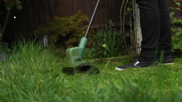 Lawn mower cutting grass. Small Green grass cuttings fly out of lawnmower pushed around by landscaper. Close Up Gardener Man working with mower machine in Garden Outside Sunny Day. Nature Family, Work — Stock Video