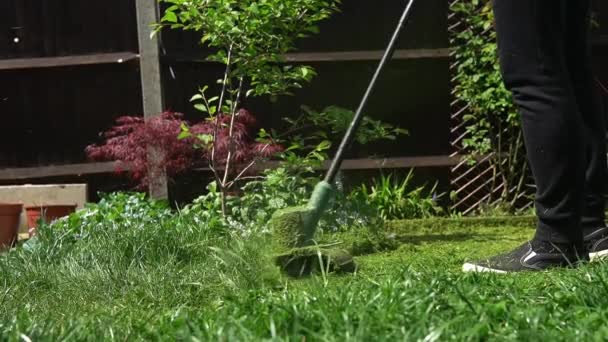 Lawn mower cutting grass. Small Green grass cuttings fly out of lawnmower pushed around by landscaper. Slow motion. Gardener Man working with mower machine in Garden Outside Sunny Day.Family, Work — Stock video