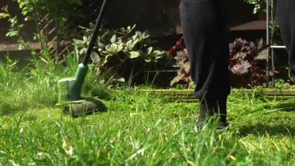 Lawn mower cutting grass. Small Green grass cuttings fly out of lawnmower pushed around by landscaper. Close Up Gardener Man working with mower machine in Garden Outside Sunny Day. Nature Family, Work — Stock Video