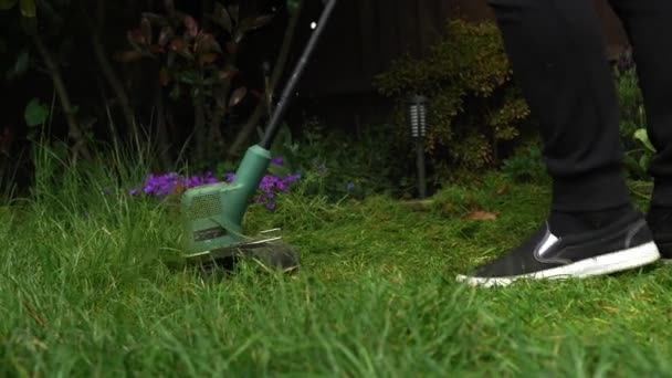 Lawn mower cutting grass. Small Green grass cuttings fly out of lawnmower pushed around by landscaper. Close Up Gardener Man working with mower machine in Garden Outside Sunny Day. Nature Family, Work — Stock video