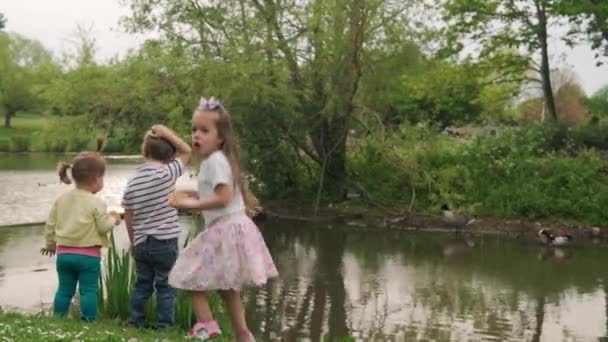 幸福的家庭湖畔有三个孩子跑腿去钓鱼 人们在公园的概念 姐妹在一起快乐的夏天 小孩跑笑小孩梦想成真的生活方式 — 图库视频影像