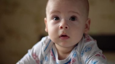 Yenidoğan Aktif Bebek Sevimli Gülümseyen Dişsiz Yüz Portresi Mide Gelişen Boyun Kontrolü Üzerine İlk Günler. 5 aylık çocuk beyaz yatakta kameraya bakıyor. Bebek, Doğum, Ebeveynlik, Başlangıç Konsepti