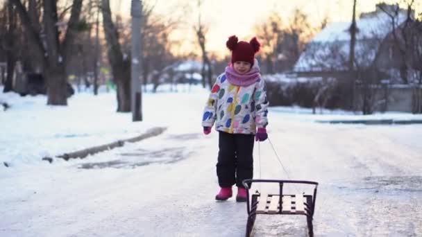 Kışın Kızakla Kayan Renkli Ceketli Komik Beyaz Okul Öncesi Kız — Stok video