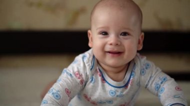 Yenidoğan Aktif Bebek Sevimli Gülümseyen Dişsiz Yüz Portresi Mide Gelişen Boyun Kontrolü Üzerine İlk Günler. 5 aylık çocuk beyaz yatakta kameraya bakıyor. Bebek, Doğum, Ebeveynlik, Başlangıç Konsepti