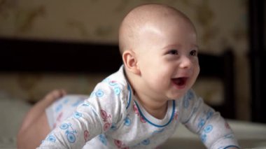 Yenidoğan Aktif Bebek Sevimli Gülümseyen Dişsiz Yüz Portresi Mide Gelişen Boyun Kontrolü Üzerine İlk Günler. 5 aylık çocuk beyaz yatakta kameraya bakıyor. Bebek, Doğum, Ebeveynlik, Başlangıç Konsepti