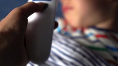 Hasta, anaokulu çocuğu portresi. Vücut ısısını ölçüyorum. Kaşıktan şurup önleyici ilaç alıyordum. Çocuk hastalıkları, hastalıklar, veli bakımı. elektronik termometre.