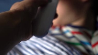 Hasta, anaokulu çocuğu portresi. Vücut ısısını ölçüyorum. Kaşıktan şurup önleyici ilaç alıyordum. Çocuk hastalıkları, hastalıklar, veli bakımı. elektronik termometre.