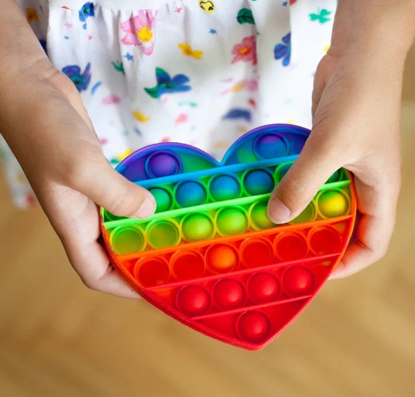 Menina Segurando Coração Forma Arco Íris Pop Brinquedo Novo Brinquedo — Fotografia de Stock
