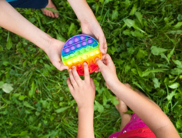 Barnens Händer Håller Runt Regnbågen Pop Den Leksak Spelar Fidget — Stockfoto