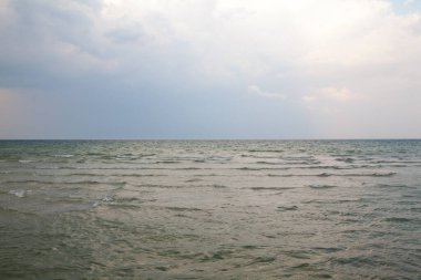 Deniz Burnu. Dalgalar ve küçük dalgalarla su yüzeyi. Gökyüzü ve bulutlar denizin üzerinde.