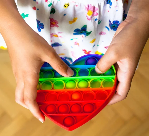 Menina Segurando Coração Forma Arco Íris Pop Brinquedo Novo Brinquedo — Fotografia de Stock