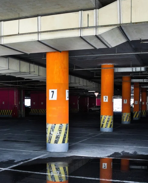 Parking Pod Budynkiem Parking Podziemny Betonowe Kolumny Liczbami Kałuże Powierzchni — Zdjęcie stockowe