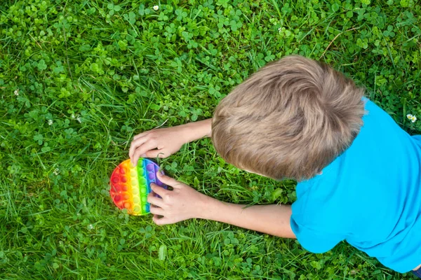 Menino Brincando Com Arco Íris Redondo Pop Brinquedo Novo Brinquedo — Fotografia de Stock