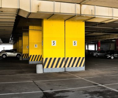 Binanın altına park etmek (otopark altı). Somut sütunlar.