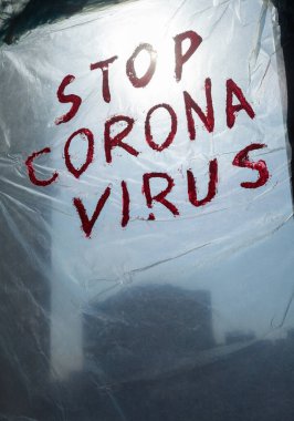 Pencereye asılmış politen yüzey üzerindeki Corona Virüsü yazısını durdur. Coronavirus (Covid-19) salgını.