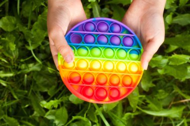 Çocuğun elleri gökkuşağını tutarken oyuncak gibi patlıyor. Yeni modayı takip eden oyuncak. Stres önleyici oyuncak. Basit gamze.