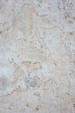 Zengin ve çeşitli dokuları olan eski, beyaz bir duvar. Çatlak alçı..