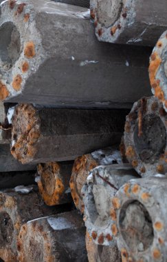 Paslı metal takviyeli beton direkler (direkler, kalınlar) yığını. İnşaat malzemesi.