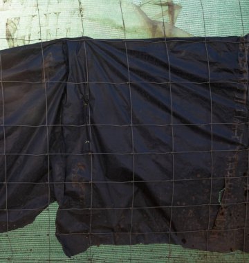 Metal tel çit ve siyah ve yeşil sentetik kumaş.. 